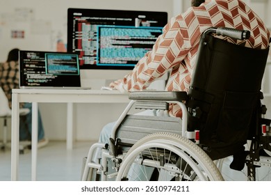 Low angle shot of unrecognizable programmer with disability coding on computer at work desk in spacious office