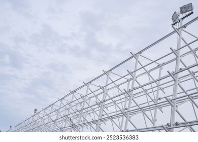 A low angle shot of a white metal structure against a cloudy sky, showcasing the geometric patterns of its framework. - Powered by Shutterstock