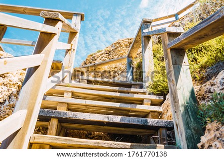 Image, Stock Photo a wooden staircase with railing leads from the sandy beach to a dune with dune grass and flagpole