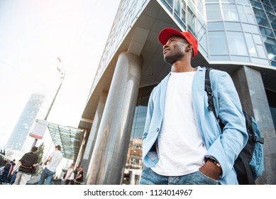 Low Angle Side View Beaming Male Traveler Going At Street Near Building. Copy Space