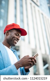 Low Angle Side View Beaming Male Typing In Phone While Locating At Street