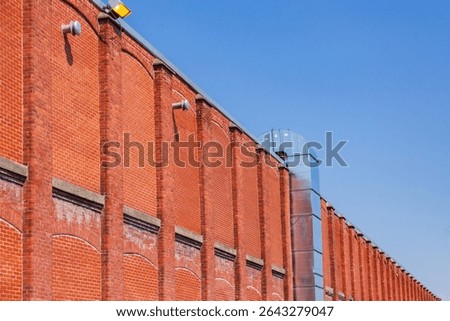 Low angle side view of old industrial building red brick wall against bright blue sky, Sherbrooke, Quebec, Canada