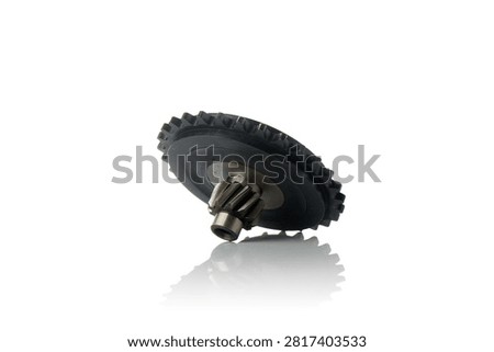 Low angle studio perspective view of engine oil pump drive gear featuring durable black plastic outer cogwheel and machined steel center pinion shaft, shot on reflective white background showcasing precision mechanical powertrain components for motorcycle repair.