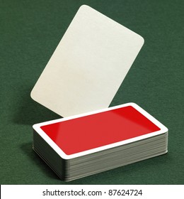 Low Angle Studio Photography Showing A Stack Of Red Playing Cards On Green Felt Background