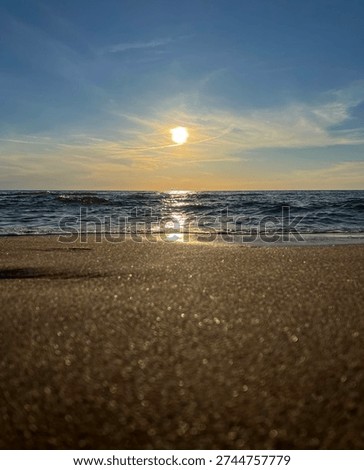 Low angle sunset over sea and sand