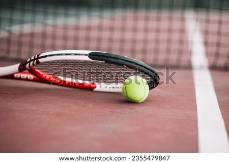 
low angle tennis racket with ball beside