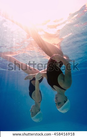 Low angle underwater view of synchronized swimming duet
