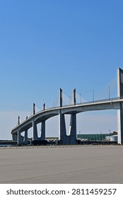 Low angle vertical view of a large modern concrete cable stayed bridge with multiple pylons under a clear blue sky, Fukushima Japan.
