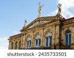 Low angle view of the 1897 National Theatre’s top story, with its magnificent neo-classical architecture and statues, San Jose, Costa Rica