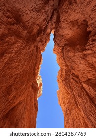 Low angle view of abstract red sandstone rock formations against clear blue sky in Wall Street canyon, Bryce Canyon.