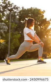 Low angle view of active fit young woman stretching out before jogging early in the morning