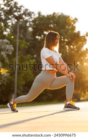 Low angle view of active fit young woman stretching out before jogging early in the morning