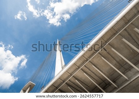 Low angle view of the Ada bridge in Belgrade, Serbia, highlighting its modern architecture against a vibrant blue sky
