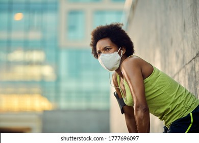 Low Angle View Of African American Sportswoman Taking A Break After Running With Protective Face Mask In The City. Copy Space. 