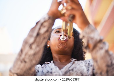 Low Angle View Of An African Woman Playing The Trumpet In The City Outside