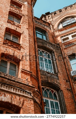 Low angle view of aged brick arches, finial and copper drainpipe