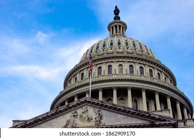 Low Angle View Of American Flag On United States Capitol Building Washington DC With Marble Dome And Blue Sky In Background