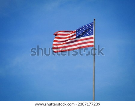 Low angle view of american flag against blue sky