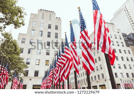 low angle view of american flags and buildings, new york, usa