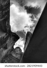 Low Angle View of Ancient Stone Ruins Against a Dramatic Cloudy Sky in Black and White, Historical Architecture and Heritage Concept Background.