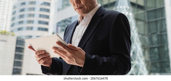 Low Angle View of An Anonymous Asian Businessman Using Digital Tablet Outside Office
