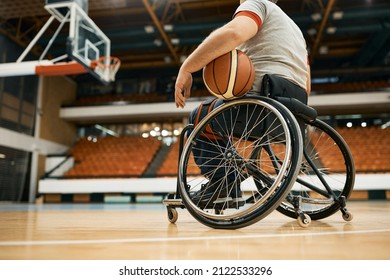 Low Angle View Of Athlete In Wheelchair Holding A Ball During Basketball Training Indoors.