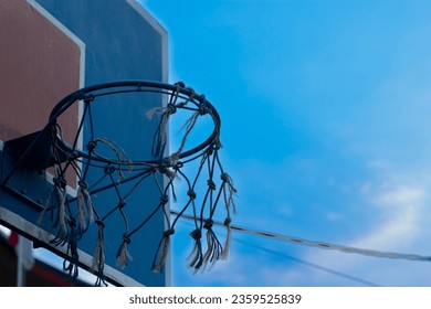 Low angle view of basketball hoop and net attached to wooden board on clear sky blue background
