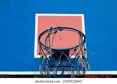 Low angle view of basketball hoop and net attached to wooden board on clear sky blue background