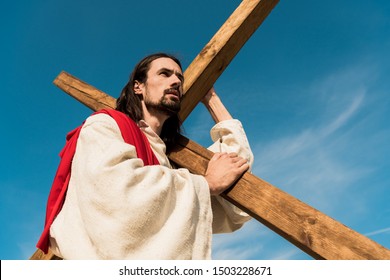 low angle view of bearded man with wooden cross 