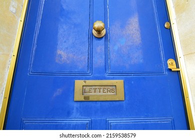 Low Angle View Of A Beautiful Old Blue Wooden Front Door With A Letter Box And Brass Handle