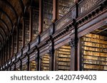 Low angle view of books on shelves in Long Room of Trinity College Old Library in Dublin.