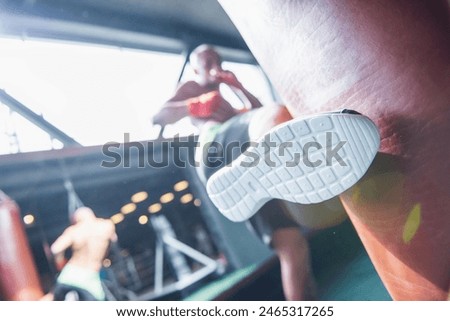 Low angle view of boxer is working out with a punching bag, his foot in focus