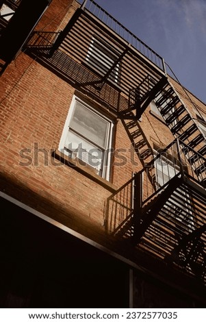 low angle view of brick building with fire escape stairs in new york city, urban architecture