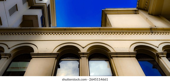 Low Angle View of Building Facade with Arched Windows and Sky
