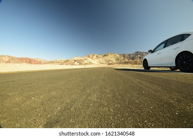 Low Angle View Of Car Heading Towards Mountains On Artist Drive In Death Valley National Park