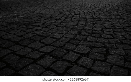 low angle view of cobble, paving stone vintage road cover with old houses, antique street. Cobblestone Road. Vintage stone street road pavement texture