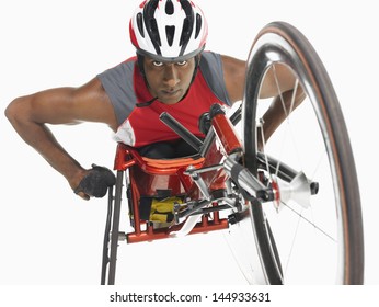 Low Angle View Of A Confident Paraplegic Cycler Against White Background