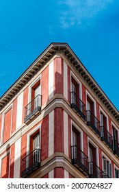 Low Angle View Of The Corner Of An Old Recently Renovated Residential Building Against Blue Sky. Vertical Shot, Symmetry