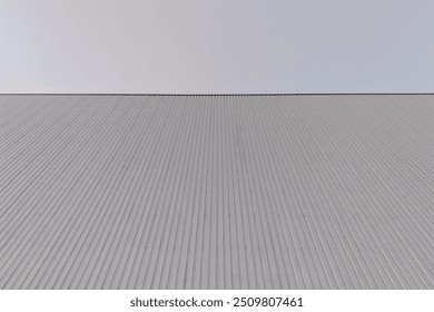 Low angle view of Corrugated Steel Warehouse,  Industrial Building against blue sky Background, Texture of a corrugated sheet metal aluminum facade. - Powered by Shutterstock