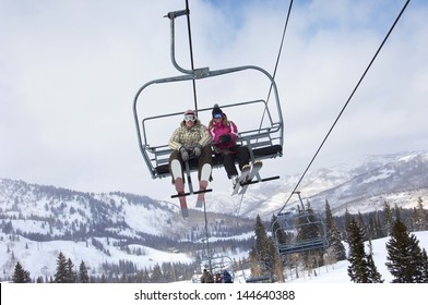 Low Angle View Of A Couple In Skies Sitting On Ski Lift