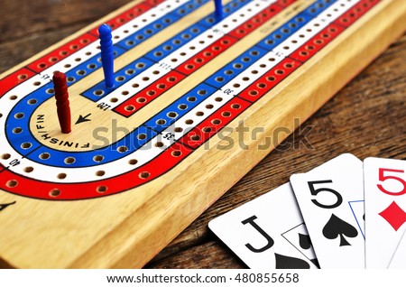 A low angle view of a cribbage board with a red cribbage peg in the winning position.