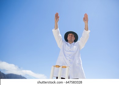 Low angle view of cricket umpire signalling six while standing against sky at match - Powered by Shutterstock