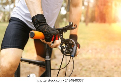 low angle view of cyclist riding mountain bike on sandy trail at sunset.  - Powered by Shutterstock