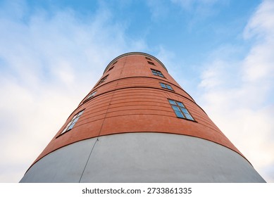 Low angle view of cylindrical red building against blue sky