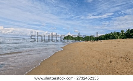 Low angle view of a deserted beach with islands in the distance under a blue sky in Sugar Beach in Sipalay, Negros Occidental, Philippines