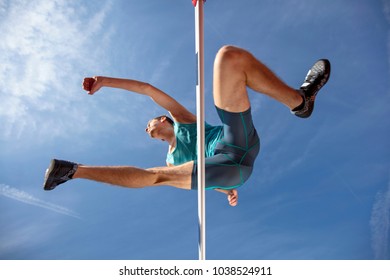 Low angle view of determined male athlete jumping over a hurdles