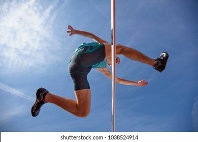 Low angle view of determined male athlete jumping over a hurdles