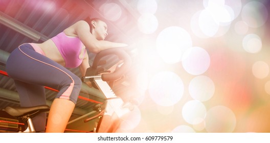 Low Angle View Of A Determined Young Woman Working Out At Spinning Class In Gym