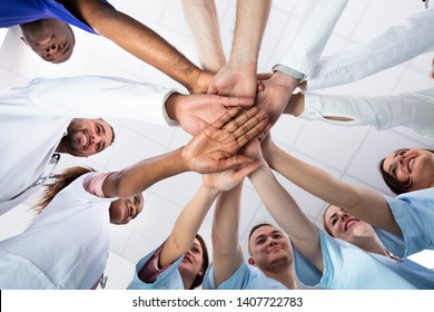 Low Angle View Of Doctor Stacking Hands Together In Hospital - Powered by Shutterstock