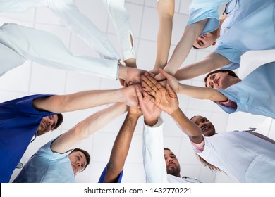 Low Angle View Of Doctor Stacking Hands Together In Hospital